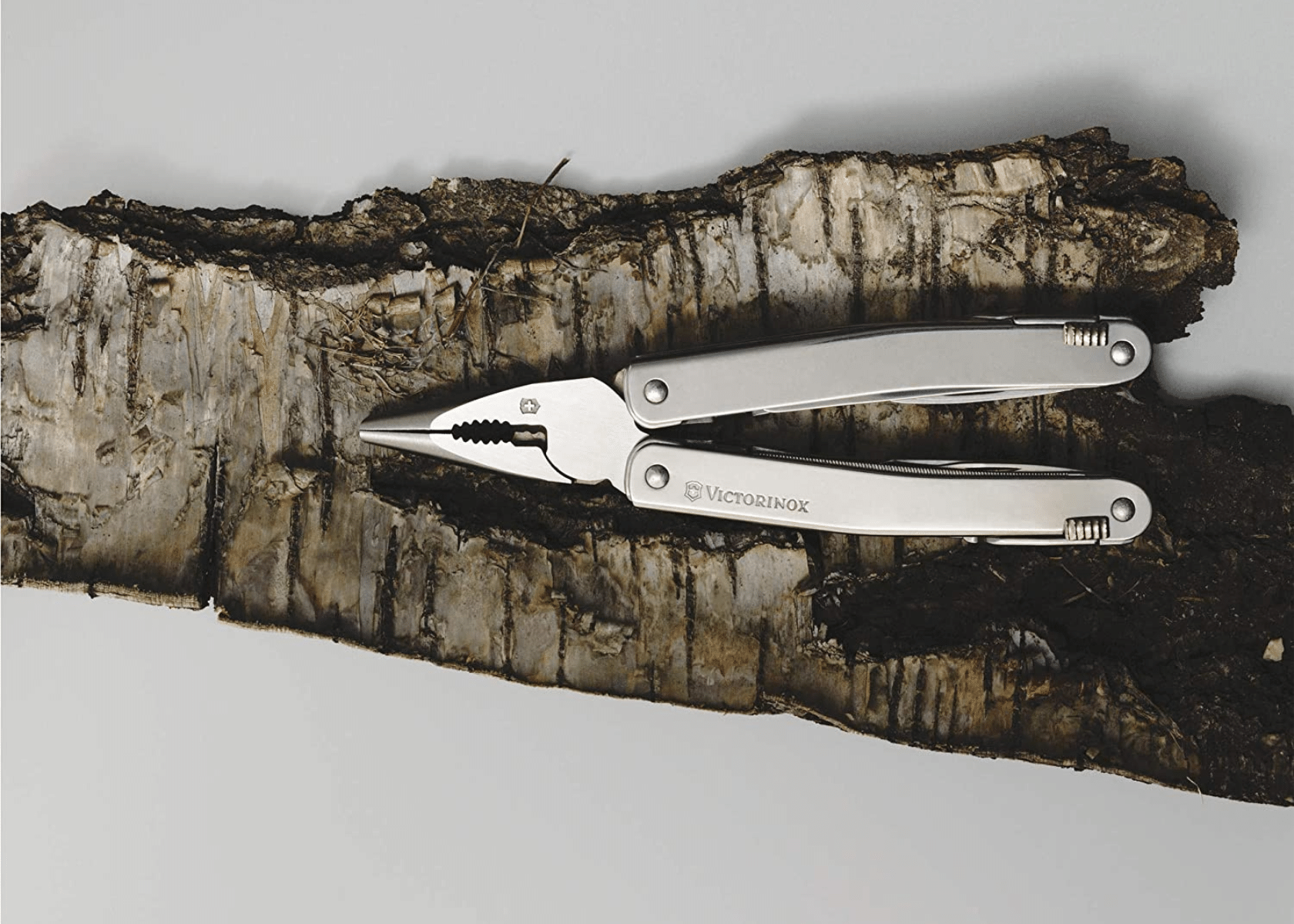 A multitool laying on a piece of wood