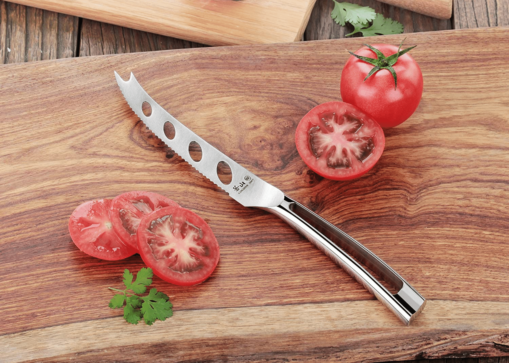 A tomato knife and tomato with tomato slices on a cutting board