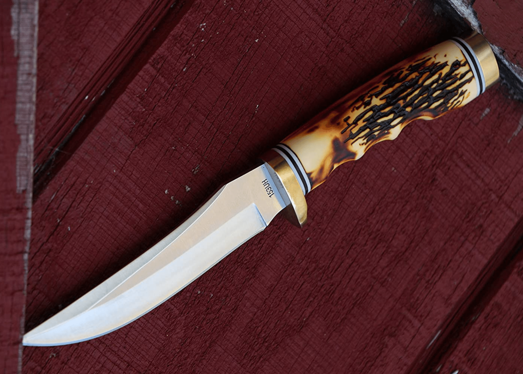 A stag handled fixed blade laying on red barn wood