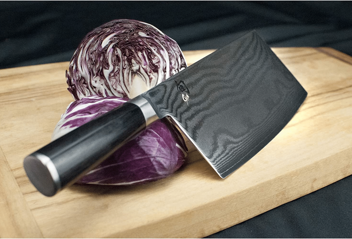 A cleave on a cutting board with purple cabbage