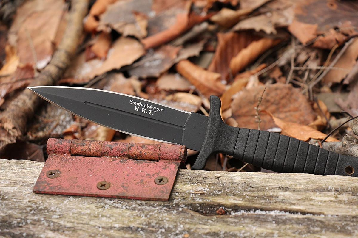 A boot knife laying on a old door in the woods