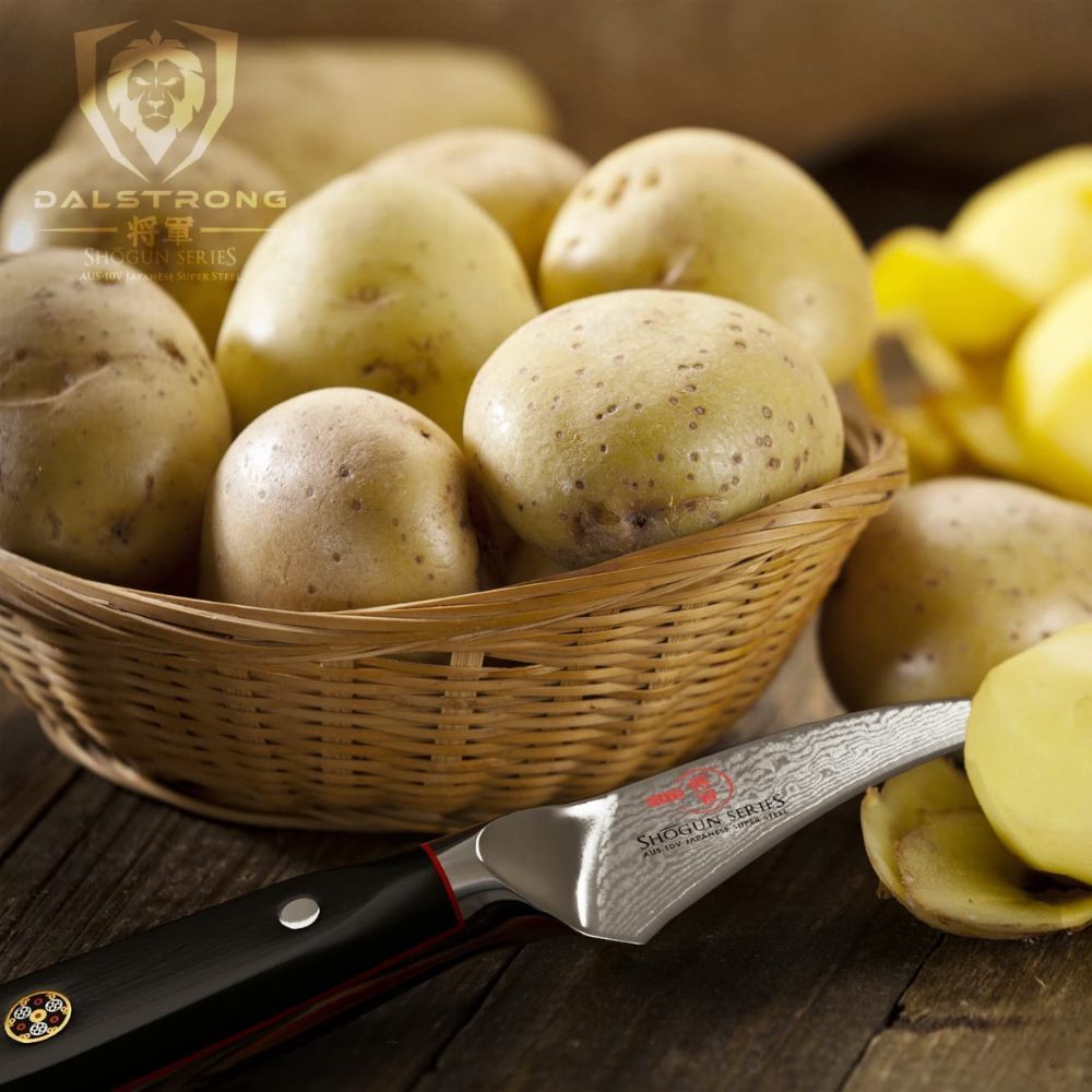 A birds beak knife on a table with a basket of potatoes.
