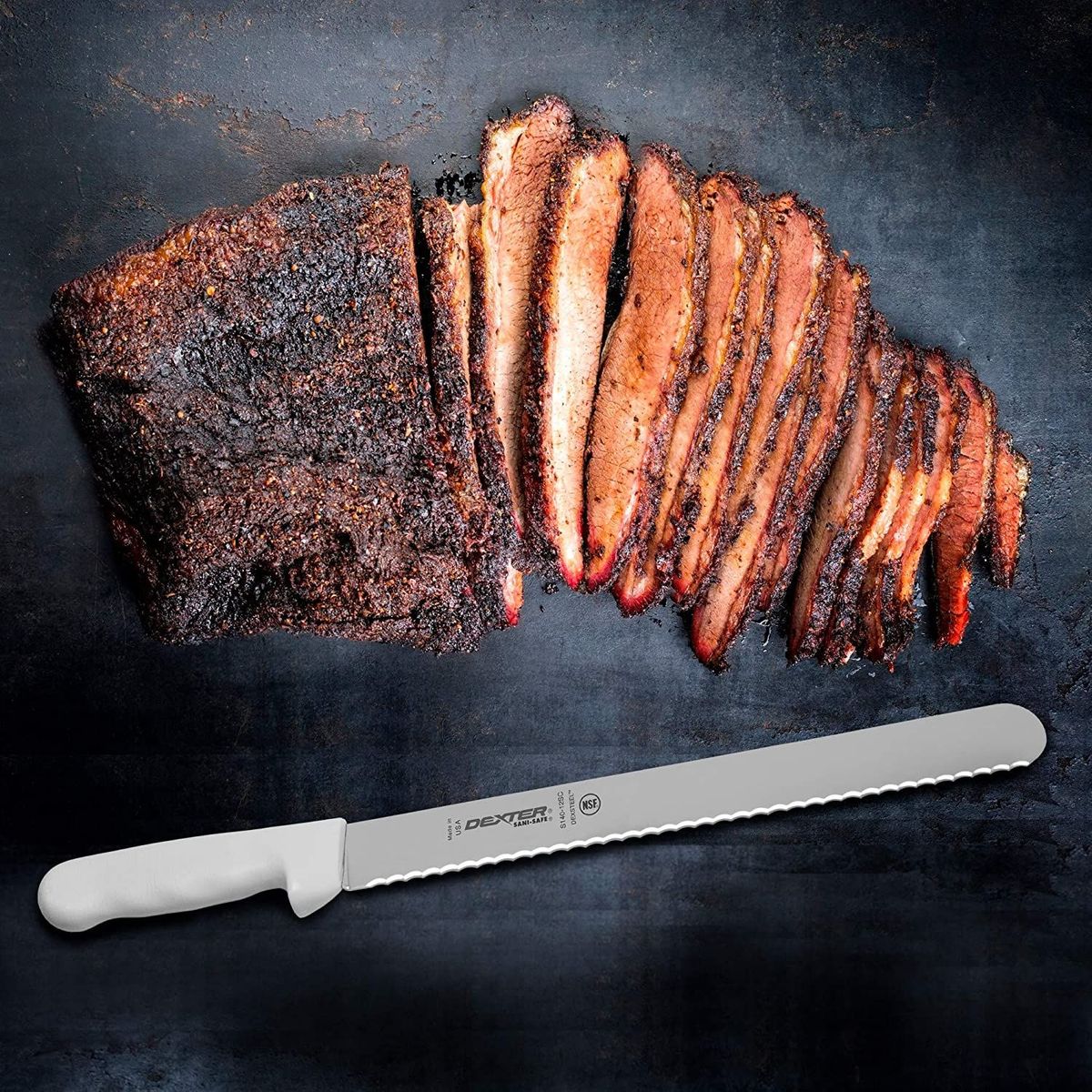 A whole brisket on counter top partially sliced with brisket knife