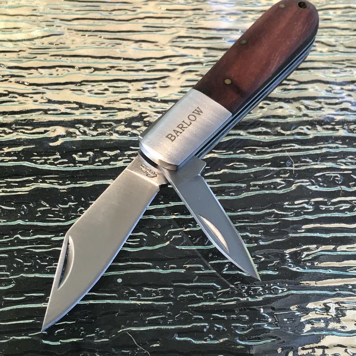 A 2-blade Barlow knife with wood handles laying on a sheet of ice