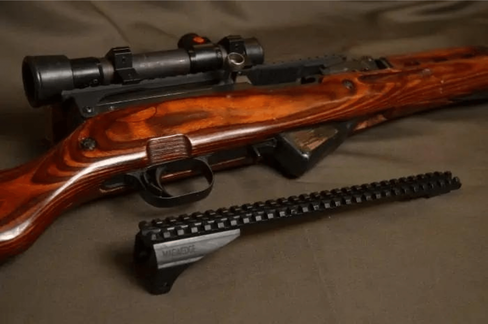 A beautiful wood SKS with a scope mounted and a SKS scope mount laying beside it