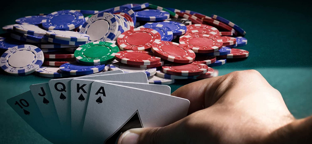 A man holding "All the cards" and a pile of chips in the middle of the table