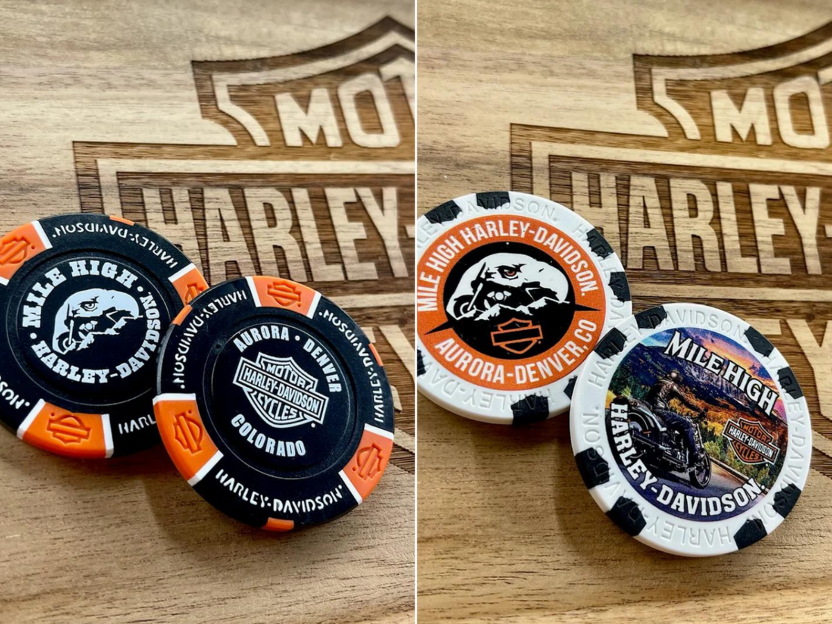 Black and orange and black and white Harley Davidson poker chips on a piece of wood with the HD Bar and Shield etched in.