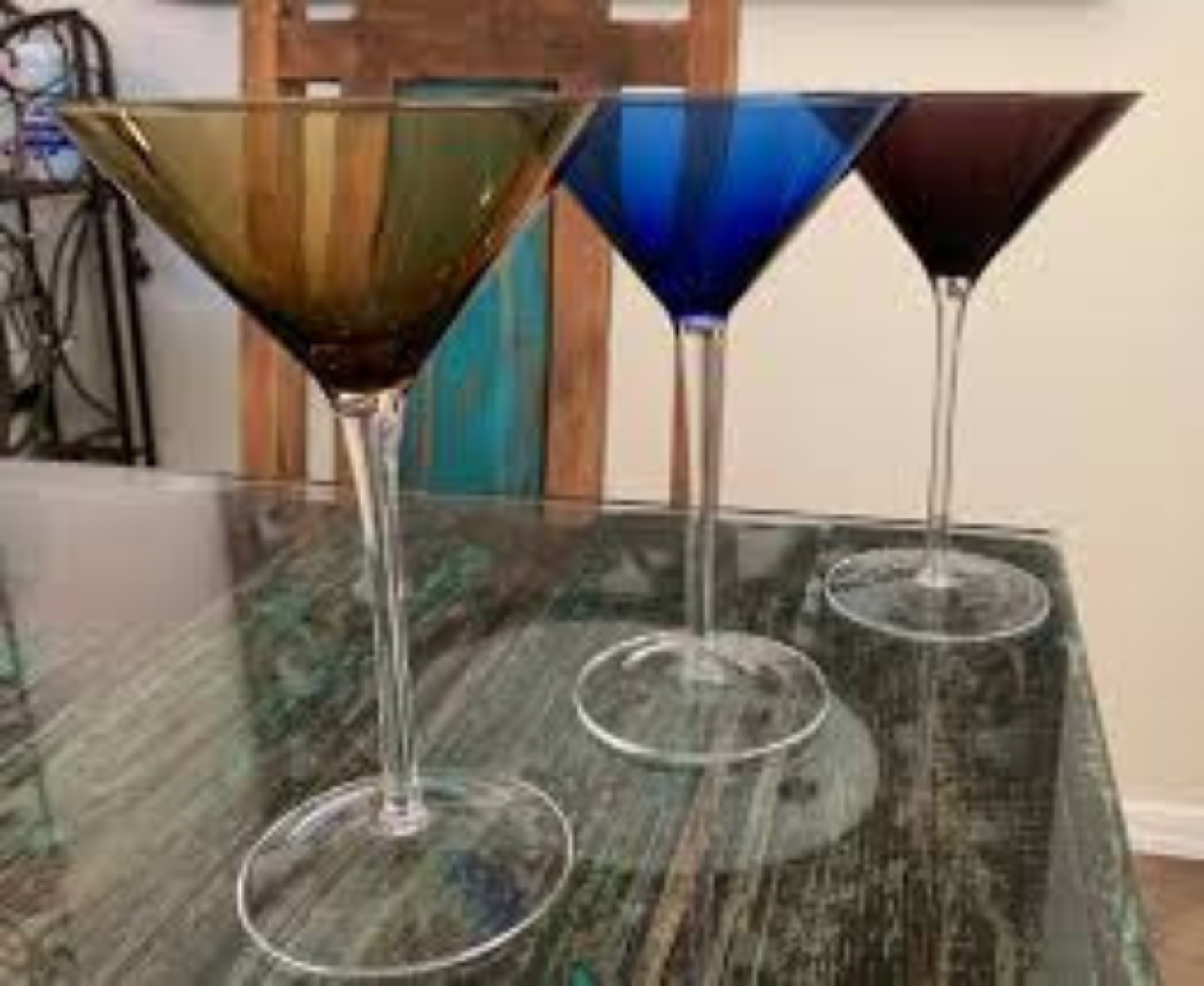 Three colored martini glasses setting on a counter.