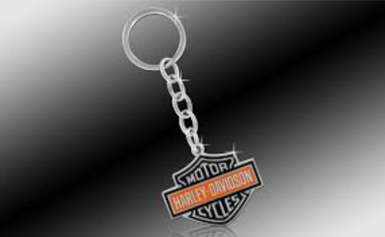 A chrome, orange, and black bar and shield logo key chain.