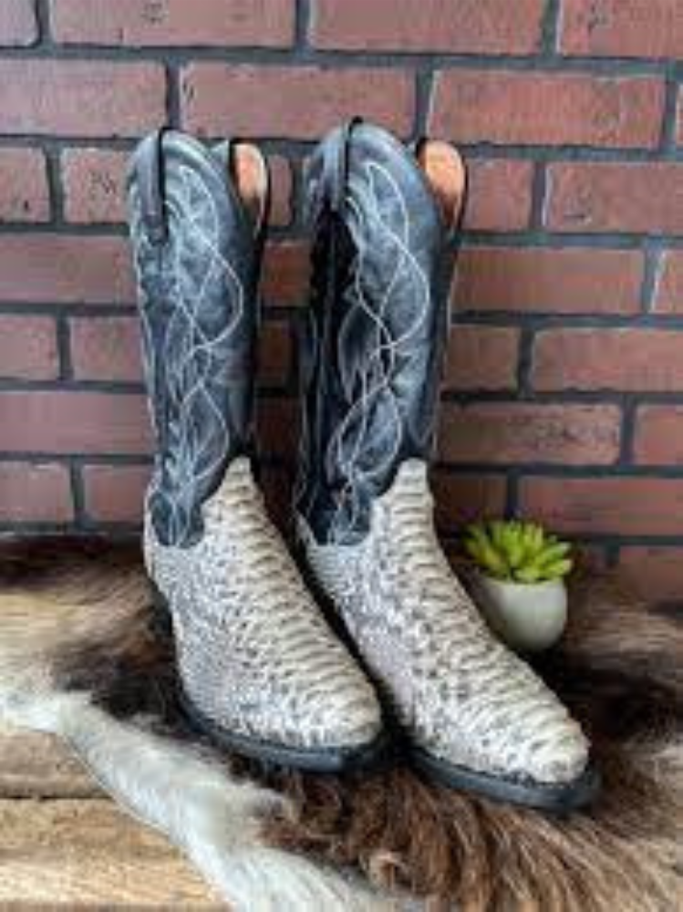 A pair of mens snakeskin boots on a fur rug.