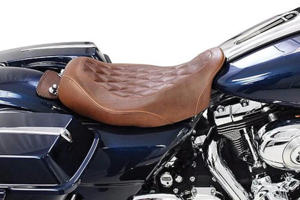 A brown solo Mustang seat on a dark blue Harley Touring bike.