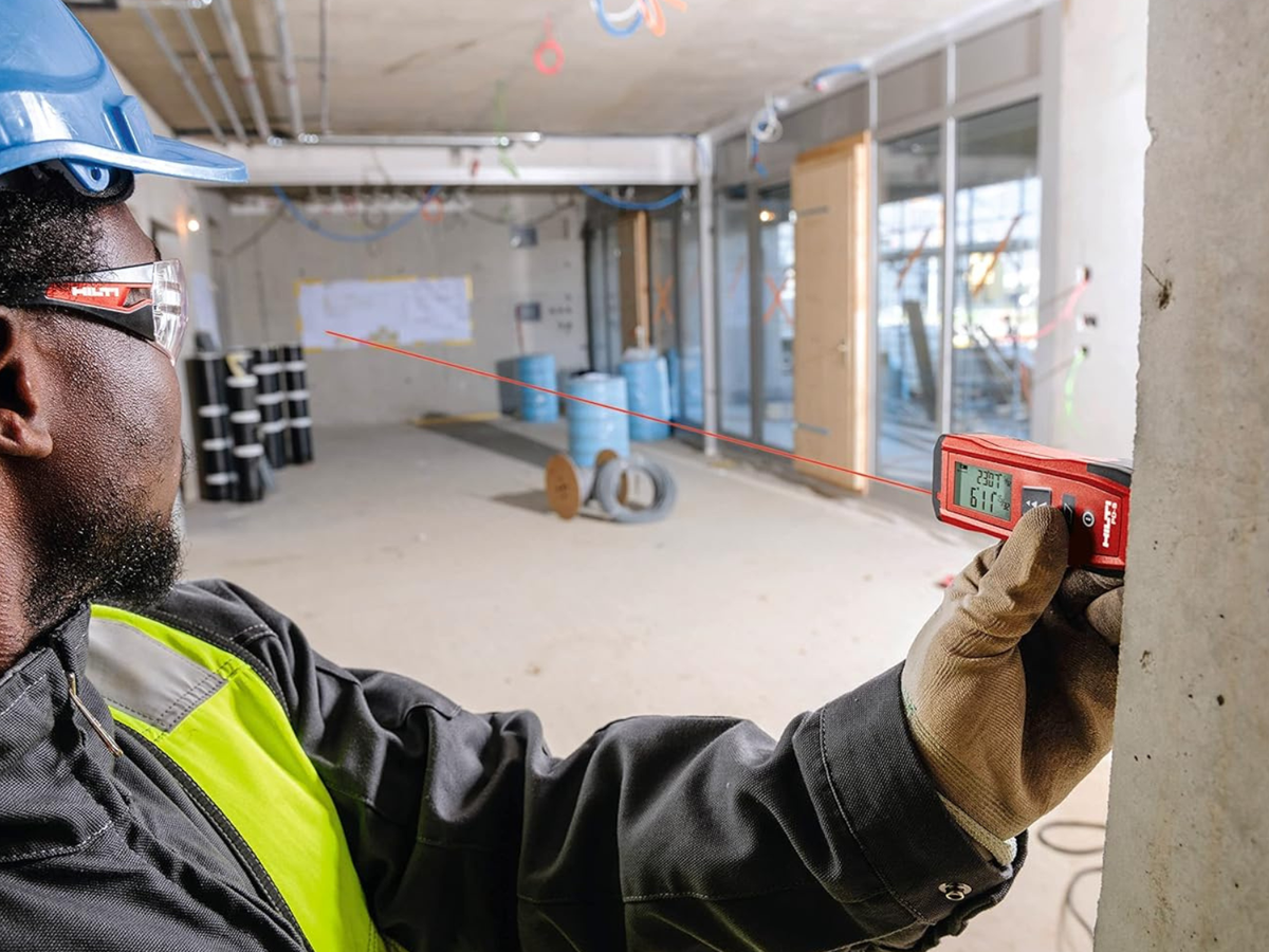 A man holding a Hilti range meter and the laser does the measuring and all you have to do is hold it.