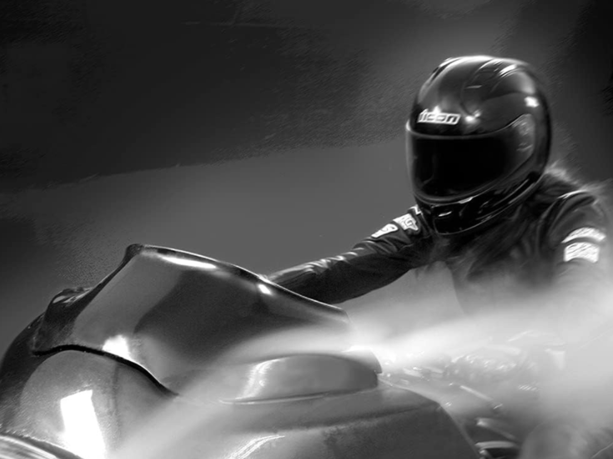 A black and white picture of a flared windshield on a bike with rider in a wind tunnel.