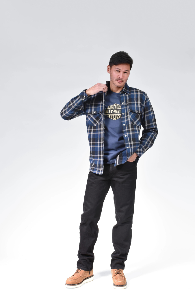 A man wearing a Harley flannel shirt over his Harley Davidson tee shirt.