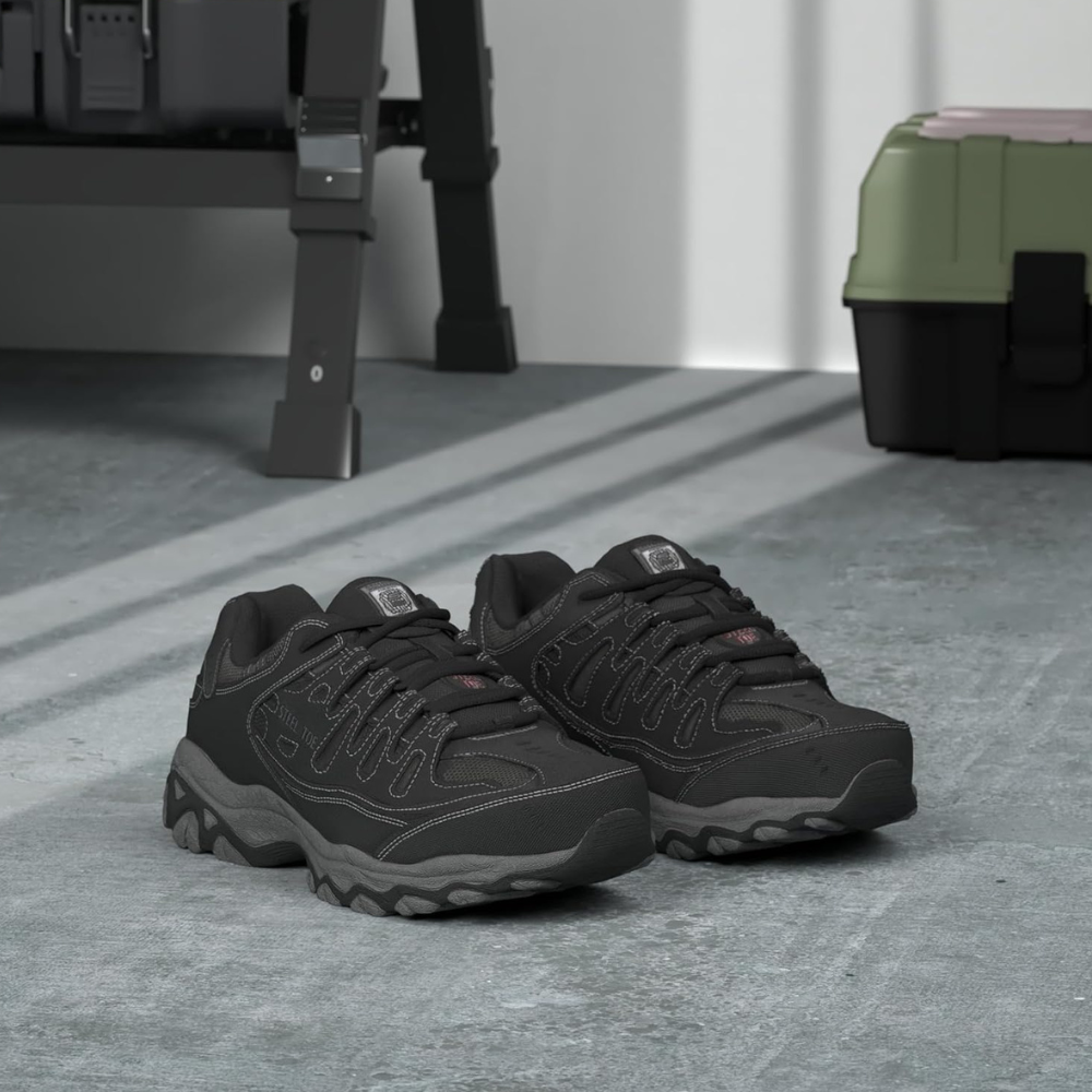 A pair of dark gray safety shoes on a gray floor.