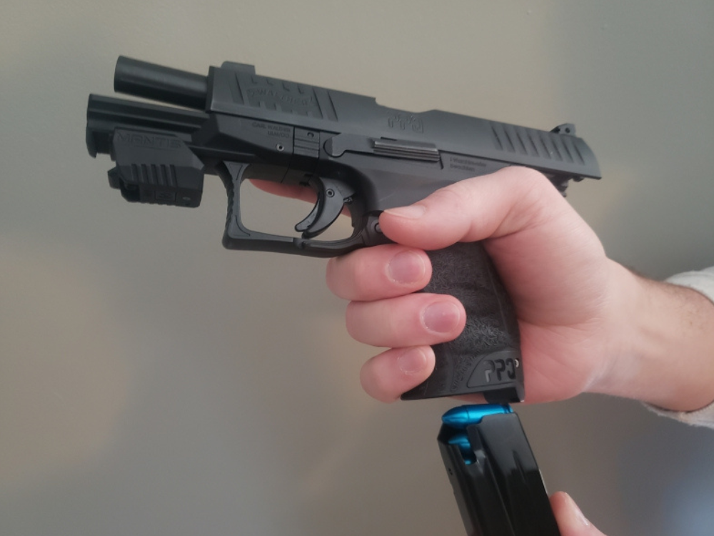 A man inserting a magazine loaded with snap caps into a pistol.