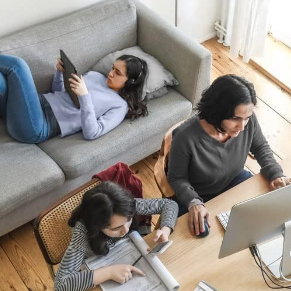 A woman and two girls using multiple wireless devices with a range extender